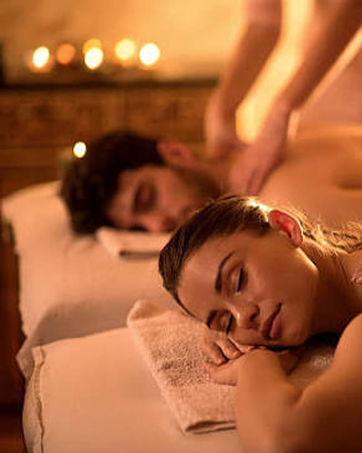 Couple enjoying a side-by-side massage in a private spa suite